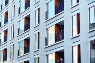 Mavi gökyüzü olan güneşli bir günde modern apartman binaları. Modern bir apartmanın cephesi