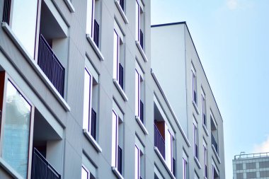 Mavi gökyüzü olan güneşli bir günde modern apartman binaları. Modern bir apartmanın cephesi