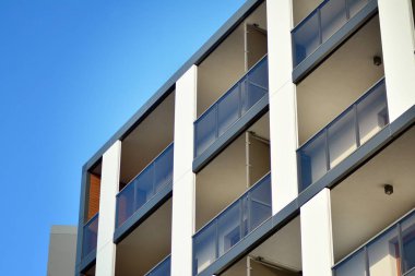 Mavi gökyüzü olan güneşli bir günde modern apartman binaları. Modern bir apartmanın cephesi