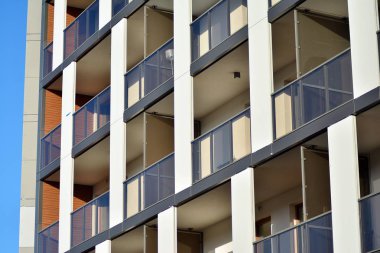 Mavi gökyüzü olan güneşli bir günde modern apartman binaları. Modern bir apartmanın cephesi