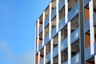 Mavi gökyüzü olan güneşli bir günde modern apartman binaları. Modern bir apartmanın cephesi