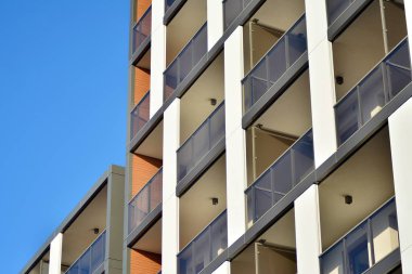 Mavi gökyüzü olan güneşli bir günde modern apartman binaları. Modern bir apartmanın cephesi