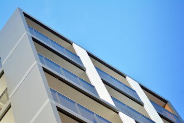 Mavi gökyüzü olan güneşli bir günde modern apartman binaları. Modern bir apartmanın cephesi