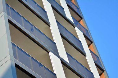 Mavi gökyüzü olan güneşli bir günde modern apartman binaları. Modern bir apartmanın cephesi