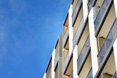Mavi gökyüzü olan güneşli bir günde modern apartman binaları. Modern bir apartmanın cephesi
