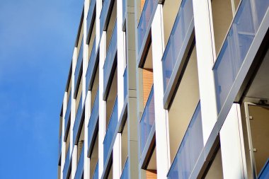 Mavi gökyüzü olan güneşli bir günde modern apartman binaları. Modern bir apartmanın cephesi