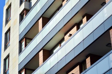 Mavi gökyüzü olan güneşli bir günde modern apartman binaları. Modern bir apartmanın cephesi