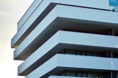 Mavi gökyüzü olan güneşli bir günde modern apartman binaları. Modern bir apartmanın cephesi