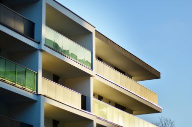 Mavi gökyüzü olan güneşli bir günde modern apartman binaları. Modern bir apartmanın cephesi