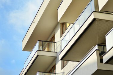 Mavi gökyüzü olan güneşli bir günde modern apartman binaları. Modern bir apartmanın cephesi
