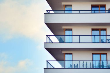 Mavi gökyüzü olan güneşli bir günde modern apartman binaları. Modern bir apartmanın cephesi