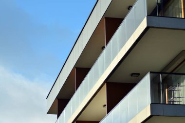 Mavi gökyüzü olan güneşli bir günde modern apartman binaları. Modern bir apartmanın cephesi