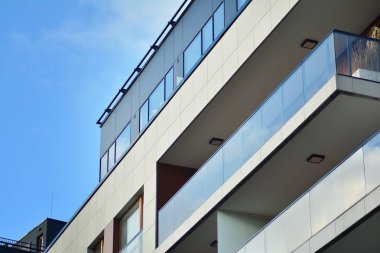 Mavi gökyüzü olan güneşli bir günde modern apartman binaları. Modern bir apartmanın cephesi