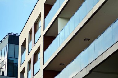 Mavi gökyüzü olan güneşli bir günde modern apartman binaları. Modern bir apartmanın cephesi
