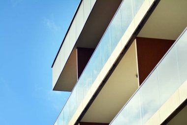 Mavi gökyüzü olan güneşli bir günde modern apartman binaları. Modern bir apartmanın cephesi