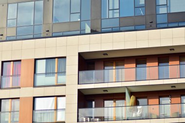 Mavi gökyüzü olan güneşli bir günde modern apartman binaları. Modern bir apartmanın cephesi