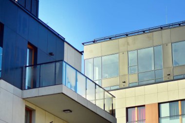 Mavi gökyüzü olan güneşli bir günde modern apartman binaları. Modern bir apartmanın cephesi