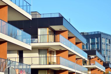 Mavi gökyüzü olan güneşli bir günde modern apartman binaları. Modern bir apartmanın cephesi