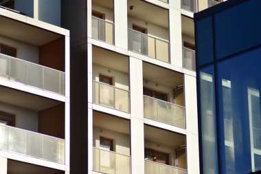 Mavi gökyüzü olan güneşli bir günde modern apartman binaları. Modern bir apartmanın cephesi