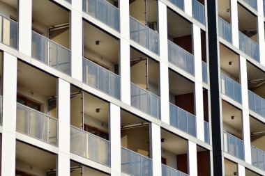 Mavi gökyüzü olan güneşli bir günde modern apartman binaları. Modern bir apartmanın cephesi