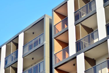 Mavi gökyüzü olan güneşli bir günde modern apartman binaları. Modern bir apartmanın cephesi