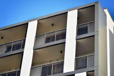 Mavi gökyüzü olan güneşli bir günde modern apartman binaları. Modern bir apartmanın cephesi