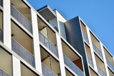 Mavi gökyüzü olan güneşli bir günde modern apartman binaları. Modern bir apartmanın cephesi