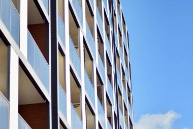 Mavi gökyüzü olan güneşli bir günde modern apartman binaları. Modern bir apartmanın cephesi