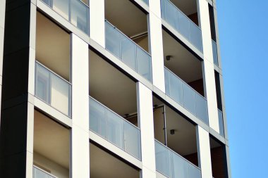Mavi gökyüzü olan güneşli bir günde modern apartman binaları. Modern bir apartmanın cephesi