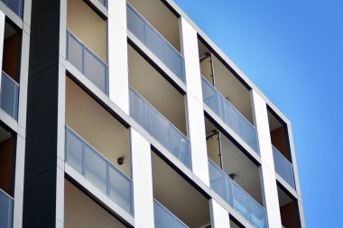 Mavi gökyüzü olan güneşli bir günde modern apartman binaları. Modern bir apartmanın cephesi