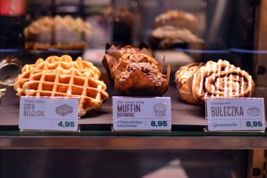 Varşova, Polonya. 23 Aralık 2018. Burger, çörek ve bir Starbucks kahve sandviç parlak bir kadeh. Fiyatları ile pişmiş fastfood parlak vitrin.