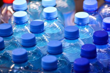 Birçok mavi kapakları ile temiz su şişesi
