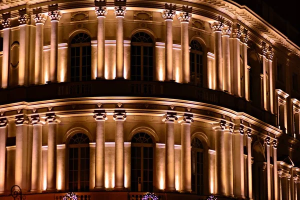 Vintage architecture classical facade illuminated at night.