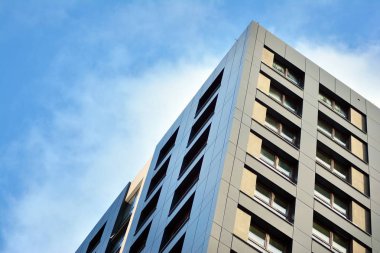 Arka planda mavi gökyüzü ve balkonları olan yeni apartmanlar.