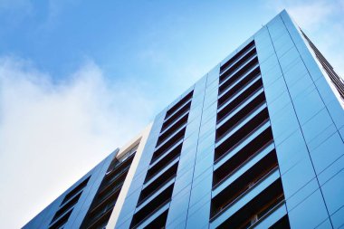 Arka planda mavi gökyüzü ve balkonları olan yeni apartmanlar.