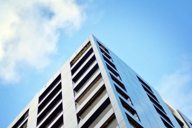 Arka planda mavi gökyüzü ve balkonları olan yeni apartmanlar.