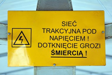 Varşova, Polonya. 6 Ocak 2019. Sarı uyarı işareti bize olası bir tehlike yüksek gerilim (Polonya alarm beyaz bir duvar karşı)
