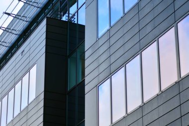 Yansıyan gökyüzü ve bulut içinde cam pencere ile modern yapı