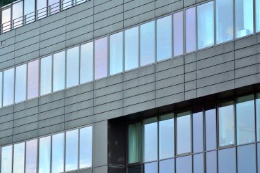 Yansıyan gökyüzü ve bulut içinde cam pencere ile modern yapı