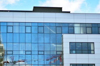 Yansıyan gökyüzü ve bulut içinde cam pencere ile modern yapı