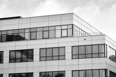 Cam pencerede yansıyan gökyüzü ve bulut ile modern bina. Siyah beyaz.