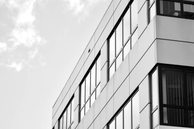 Cam pencerede yansıyan gökyüzü ve bulut ile modern bina. Siyah beyaz.