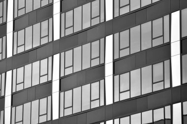 Cam pencerede yansıyan gökyüzü ve bulut ile modern bina. Siyah beyaz.