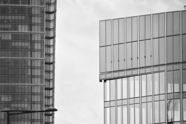 Cam pencerede yansıyan gökyüzü ve bulut ile modern bina. Siyah beyaz.