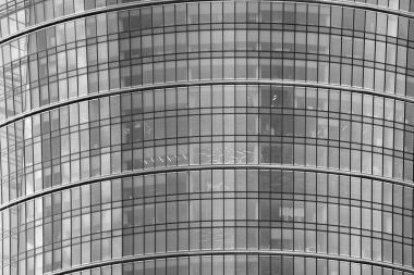 Cam pencerede yansıyan gökyüzü ve bulut ile modern bina. Siyah beyaz.