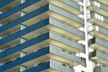 Mavi gökyüzü olan güneşli bir günde modern apartman binaları. Modern bir apartmanın cephesi