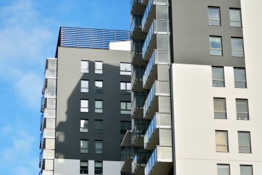 Mavi gökyüzü olan güneşli bir günde modern apartman binaları. Modern bir apartmanın cephesi
