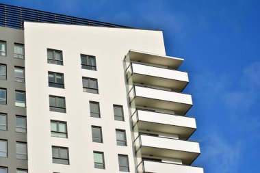 Mavi gökyüzü olan güneşli bir günde modern apartman binaları. Modern bir apartmanın cephesi