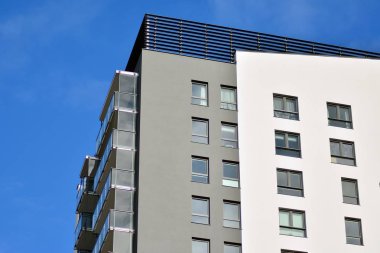 Mavi gökyüzü olan güneşli bir günde modern apartman binaları. Modern bir apartmanın cephesi