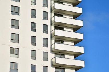 Mavi gökyüzü olan güneşli bir günde modern apartman binaları. Modern bir apartmanın cephesi